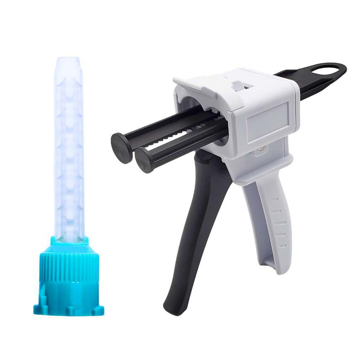 A white and black dual-plunger dental dispensing gun and a separate static mixing tip with a blue base, isolated on a white background.