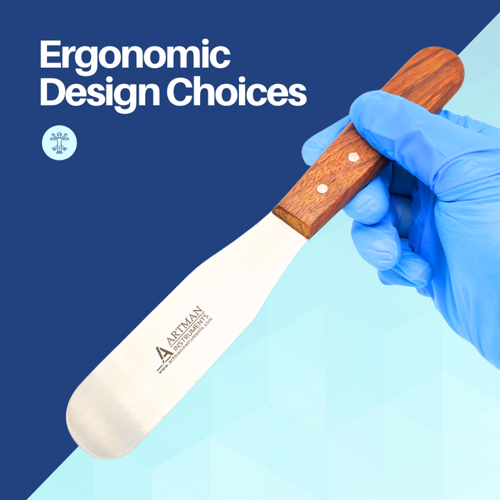 A close-up of a hand in a blue medical glove holding a plaster spatula, highlighting its ergonomic wooden handle design.